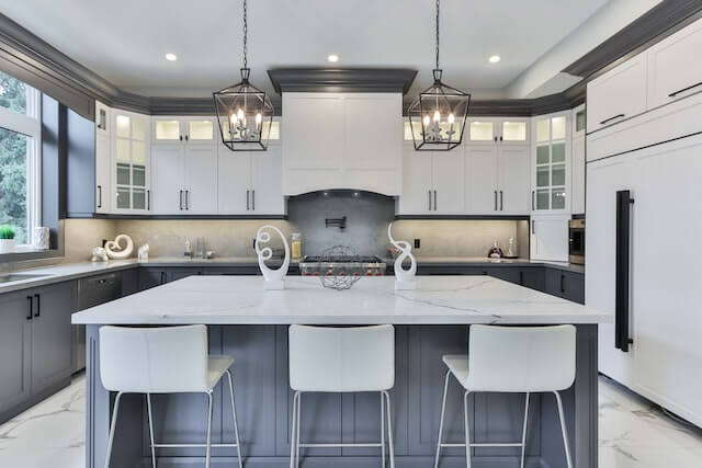 Blue chairs and a black kitchen island with a marble top